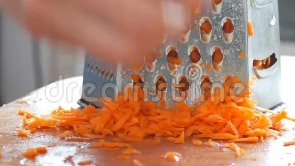 雌性的手擦在磨碎的胡萝卜上视频的预览图