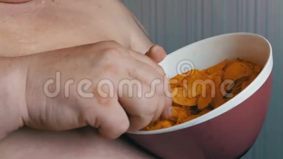 胖子用手拿着大盘子吃薯片视频的预览图