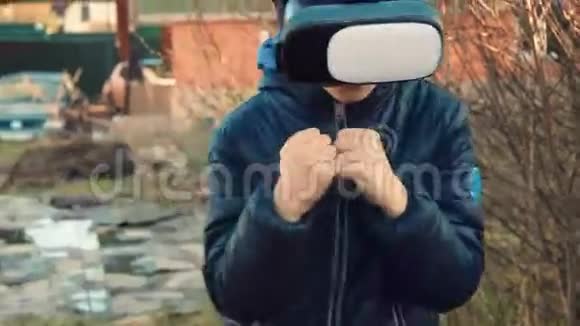 小男孩用虚拟现实耳机在后院玩游戏视频的预览图