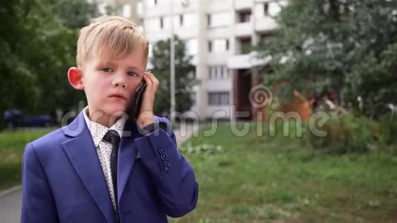 穿着西装的男孩在公园里用手机说话前面看脸视频的预览图