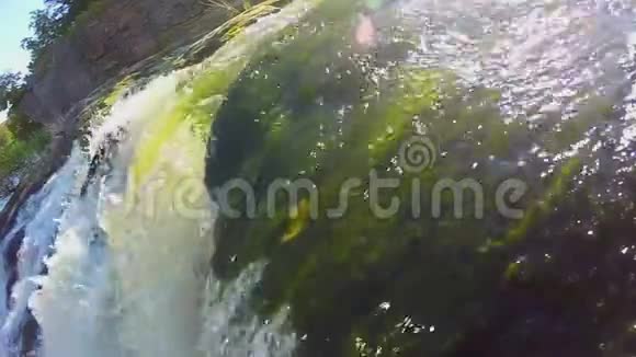 在岩石上瀑布上缓缓移动的绿色水视频的预览图
