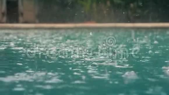 雨滴掉进水里雨下美丽的水池水面慢动作视频的预览图