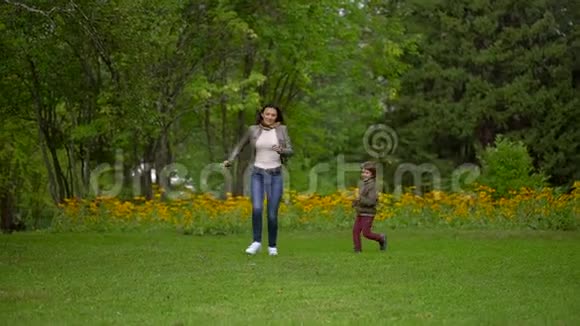 年轻的母亲或妹妹和一个非常可爱的小男孩在夏天公园玩慢动作视频的预览图