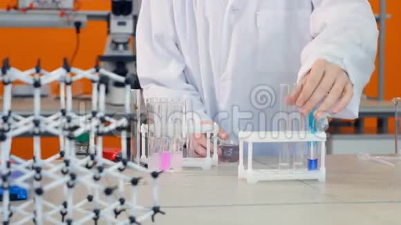 中学生在实验室做化学测试手将化学试剂加入小瓶试管中视频的预览图