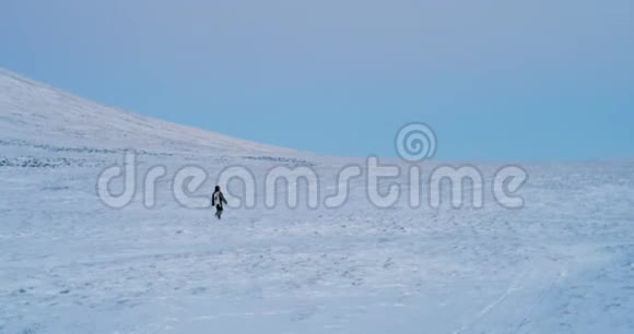 4K镜头在寒冷的冬天下午穿着温暖衣服的人独自在宽阔的地方散步红色史诗视频的预览图
