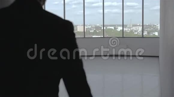 慢动作穿黑色西装带文件夹的商人在白色大厅里视频的预览图