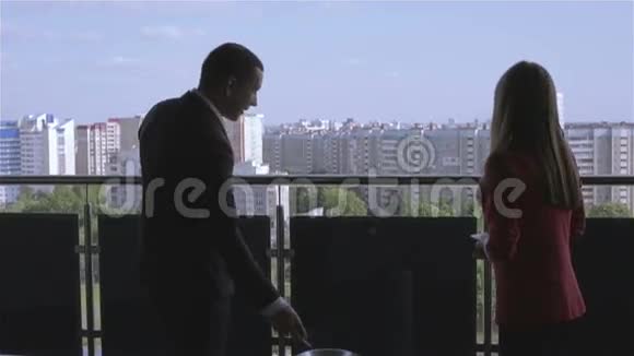 商人和女商人站在阳台上视频的预览图