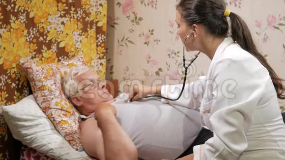 一位女医生在家里用听音筒听病人说话那个人躺在沙发上视频的预览图