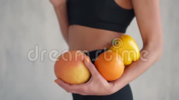 运动女性手里拿着新鲜水果和蔬菜健康的饮食观念视频的预览图