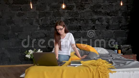 情侣躺在床上使用笔记本电脑快乐微笑在线聊天和吃薯片和苹果女孩和男人视频的预览图