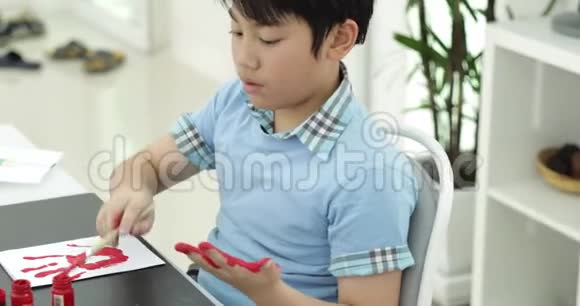 快乐的亚洲可爱的孩子在你的手上画水色带着微笑的脸视频的预览图