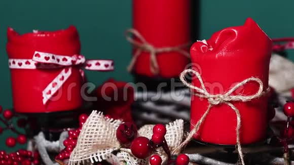 现代圣诞花环木质表面有四支红色蜡烛绿色背景视频的预览图