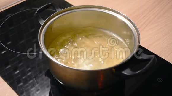 在金属平底锅中煮水在水中煮长通心粉视频的预览图