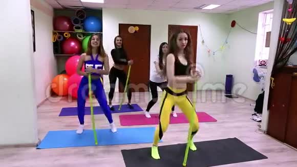 一群年轻的白种人妇女在健身室里用棍子做运动视频的预览图