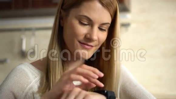 漂亮的年轻女人用手指在智能手表的触摸屏上做各种手势视频的预览图
