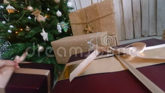 女人把礼物放在圣诞树下视频的预览图