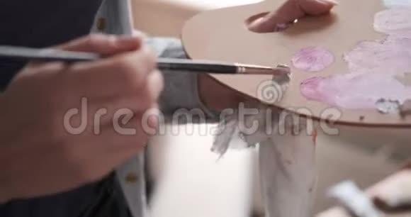 女艺术家在调色板上混合水彩视频的预览图