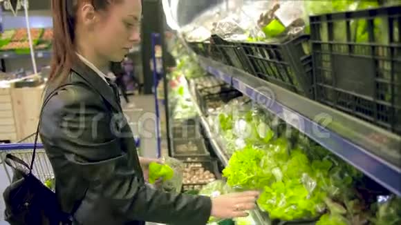 美丽的女人在超市买蔬菜和水果深色头发的女人选择西红柿和胡椒新鲜沙拉视频的预览图