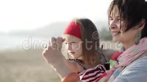 年轻的母亲和小女儿在沙滩上跳舞视频的预览图