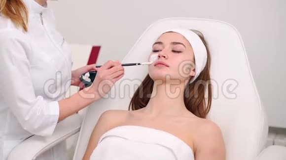 美容专家使用刷子涂抹面膜使皮肤水润健康迷人的女人令人放松视频的预览图