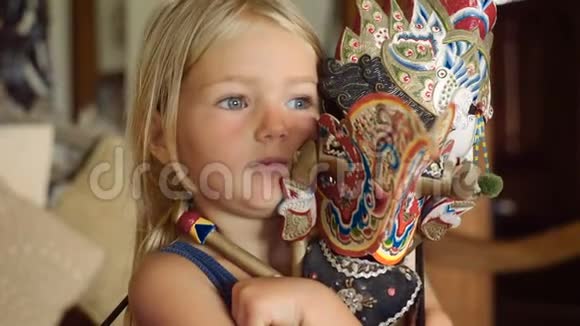 抱着一个巴厘岛娃娃的小女孩深思视频的预览图