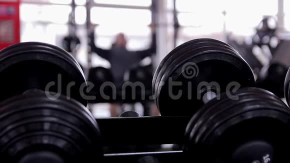在健身房做长凳按压运动的男性运动员的离焦轮廓视频的预览图