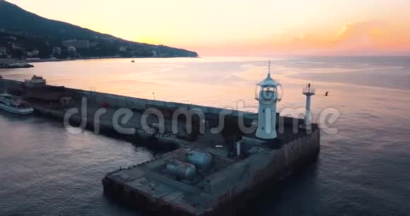 船只灯塔和海上日出山谷边缘的史诗太阳耀斑4k无人机飞行视频的预览图