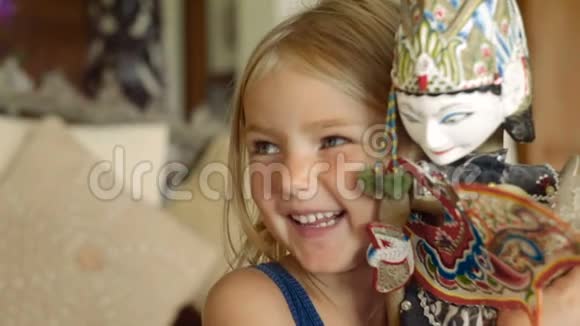 小女孩微笑着拥抱一个巴厘岛娃娃视频的预览图
