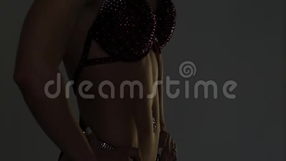 肌肉发达的女性身体在黑暗中女性健美运动员运动后的姿势慢动作视频的预览图