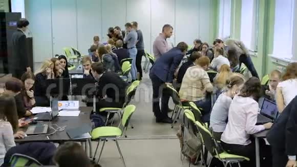 学生分成几组坐在长桌旁执行老师控制的任务视频的预览图