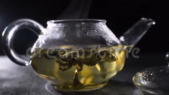 茶叶酿造绿茶叶在玻璃壶中旋转视频的预览图