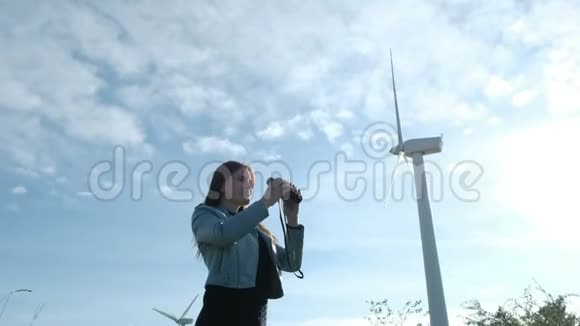 成年女孩在风车附近看望远镜视频的预览图