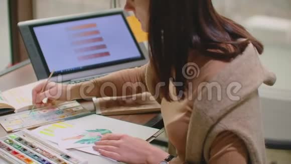 年轻的平面设计师在办公室的办公桌上使用平面平板电脑时使用现代台式电脑视频的预览图