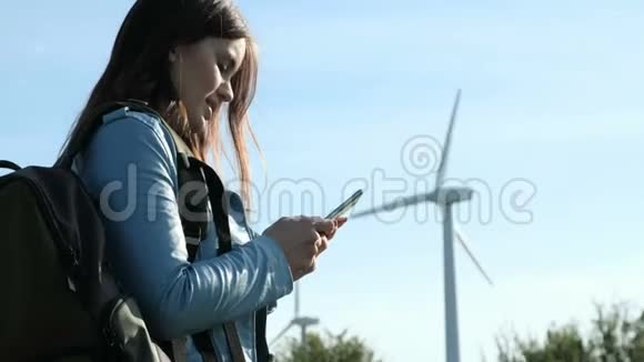 在风车农场附近打电话的女孩视频的预览图