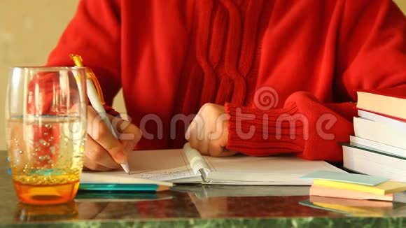 写日记的女人在桌子上拿着一杯水视频的预览图