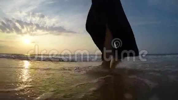 一个女人在沿着海岸散步时脚的慢镜头视频的预览图