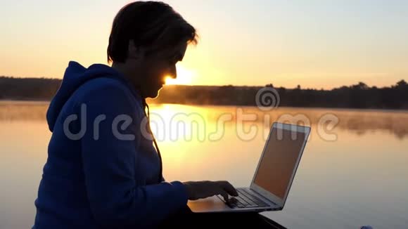 日落时分女人在湖畔写文章视频的预览图