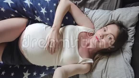 开朗的孕妇躺在床上视频的预览图