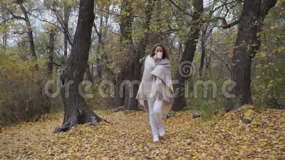 美丽的女人在秋天公园散步视频的预览图