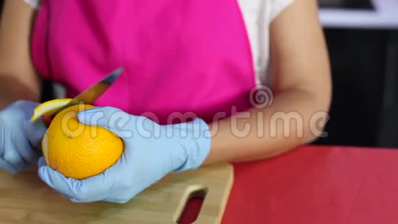 一位年轻的家庭主妇在厨房里剥橘子水果视频的预览图