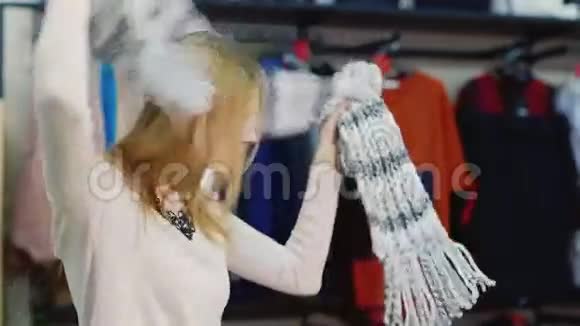 有魅力的女人在服装店里试穿一个模特看起来很暖和愉快的购物视频的预览图