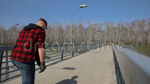 穿着长板溜冰鞋的酷男在桥上视频的预览图