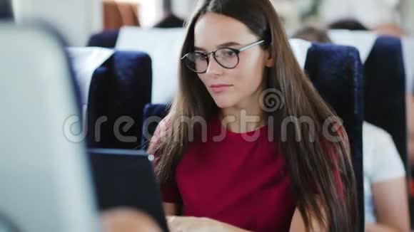 坐在火车上用笔记本电脑的年轻女子视频的预览图