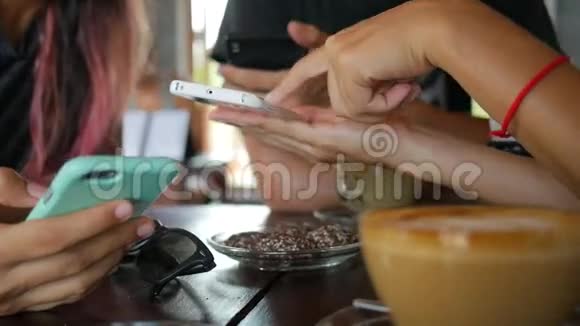 年轻的朋友在坐在咖啡厅的手机上展示照片泰国视频的预览图