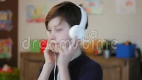 一个可爱的小男孩戴着耳机听音乐的肖像视频的预览图