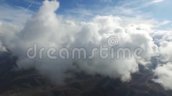 不可思议的空中无人机4k相机高高飞扬在蓬松的白色雨云中在晴朗的蓝天上景视频的预览图