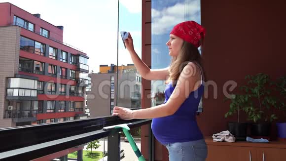 小心孕妇在公寓阳台擦拭窗户灰尘视频的预览图