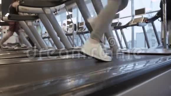 跑步机健身房里跑步的女性腿部特写视频的预览图