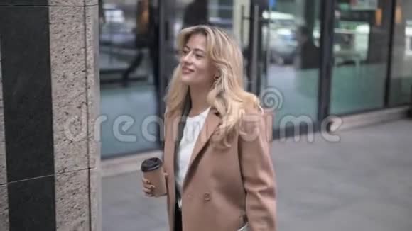 金发女人在秋街边喝咖啡视频的预览图