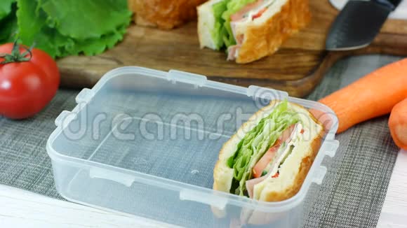 女人把新鲜的三明治放进饭盒里视频的预览图